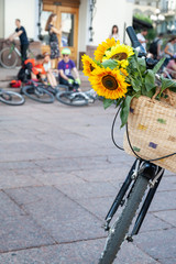 Fototapeta na wymiar Kyiv, Ukraine - June 27, 2019: Girls' Bike Show-KYIV CYCLE CHIC. Basket with yellow flowers on a bicycle.