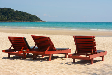 Wooden lounge chairs on beautiful tropical beaches.