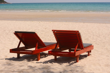Fototapeta na wymiar Wooden lounge chairs on beautiful tropical beaches.
