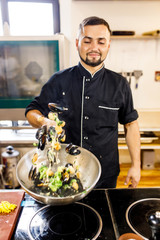chef cooks mussels in a restaurant