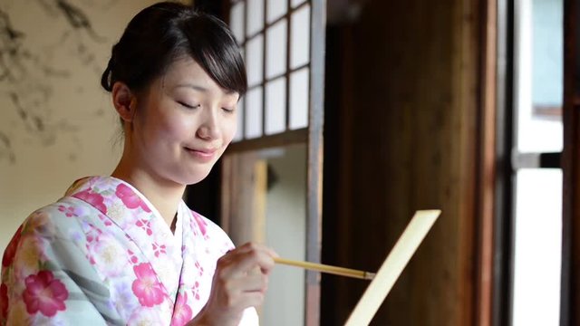 Young Japanese woman practicing calligraphy
