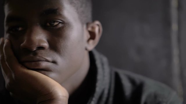 worried pensive lonely american african young man thinking in the dark