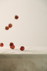 Falling red apples on table background