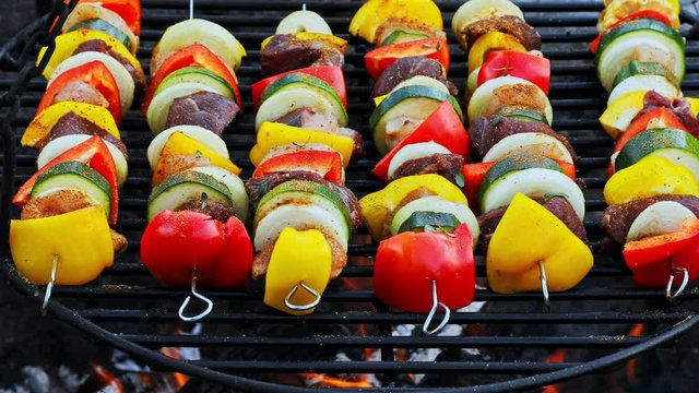 Homemade and hot skewers with meat and vegetables on grill