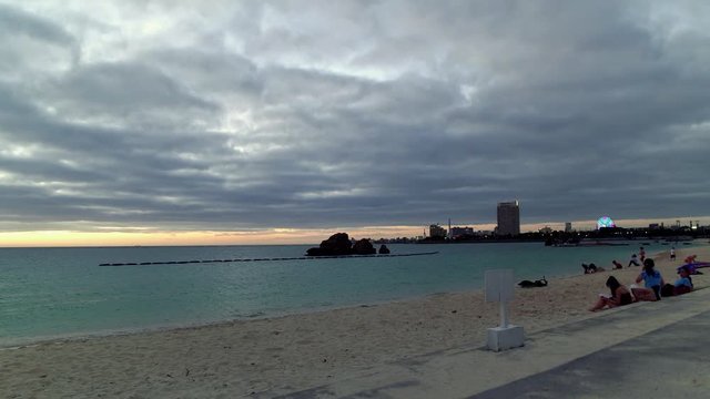 Araha Beach with people at sunset, Ginowan, Okinawa Prefecture, Japan