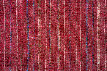 Red coarse fabric with thin stripes of a different color. Texture fabric blank background