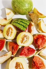 Naklejka premium Sliced ripe juicy melon and watermelon on a white background. Top view.