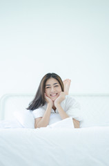 Asian women Smiled on the white futon in her bedroom.Beautiful woman smiling.