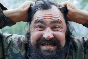 a black bearded man with a grin on his face, growls. Looks like an terrorist