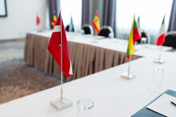 business, corporate and interior concept - flags on table in boardroom at international conference