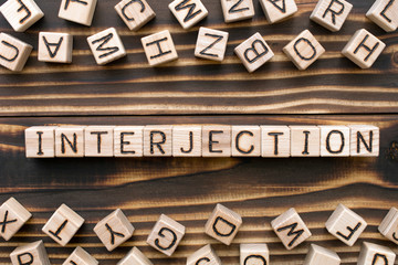 interjection - word from wooden blocks with letters, *** concept, random letters around, top view...