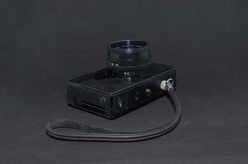 old film camera with strap close-up on a black background