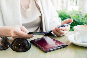 A woman in a white jacket, paying by credit card online, making orders over the Internet. Successful woman businessman making a transaction using mobile banking application. Selective focus