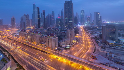 Fototapeta na wymiar Dubai downtown skyline night to day aerial timelapse with traffic on highway