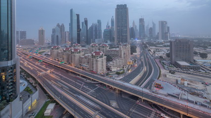 Fototapeta na wymiar Dubai downtown skyline night to day aerial timelapse with traffic on highway