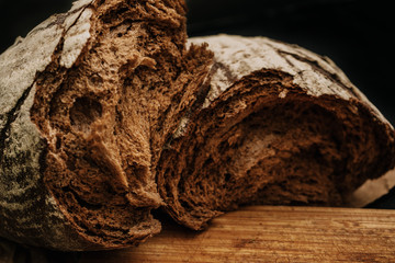 Fresh bread on paper on wooden black background