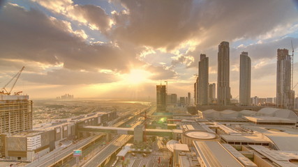 Sunrise aerial view of Financial center road morning timelapse with under construction building