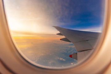 Silhouette of Airplane wing view out of the window the cloudy sunset sky background, Travel and Holiday vacation concept