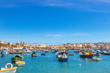 Fototapeta na wymiar The traditional eyed boats in the harbor of fishing village Marsaxlokk in Malta