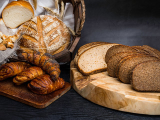 Different bread with ears in basket on concrete background
