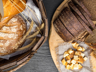 Variety of fresh tasty bread on wooden table