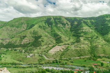 Panoramic view of Vardzia cave monastery town. View from the monastery to the river valley and green slopes on a sunny summer day