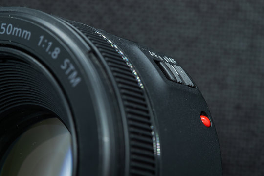 Macro close-up photo of lens to DSLR camera on dark background front view with focal range and aputure description.