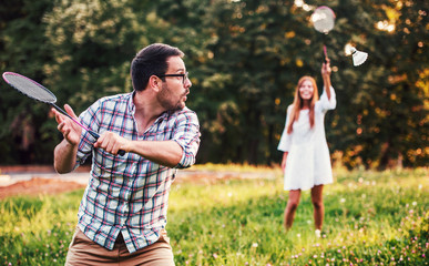 Couple playing badminton in the park. Sport, recreation, lifestyle, love concept