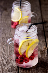 Infused Water with Lemon and Raspberry Healthy Detox Drink Cold Berry Fruit Lemonad in Glass Jars Wooden Background Vertical