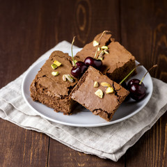 Tasty Homemade Chocolate Brownie with Nuts on a Linen Napkin Wooden background White Plate