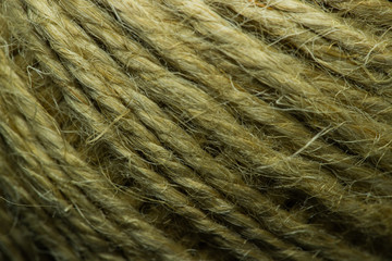 Close-up macro view of twine or string from natural fabric wrapped in a ball.