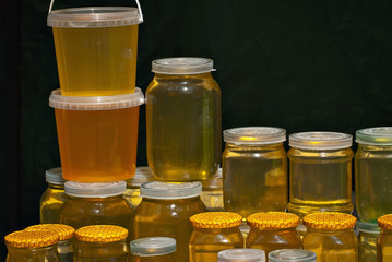 Lots of assorted honey on the table. Jars of sweets are sold at the fair.