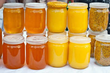 Lots of assorted honey on the table. Jars of sweets are sold at the fair.
