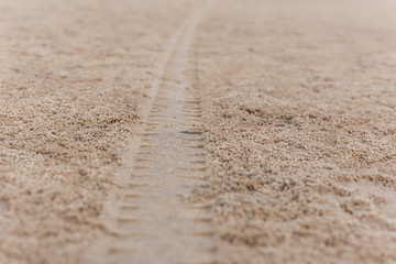 Fototapeta na wymiar Background texture of car tyre track on sandy beach.