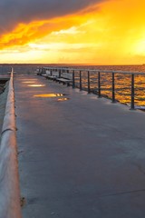 Obraz premium Dramatic summer sunset over sea. Scenic landscape with pier on the sea during beautiful sunset. Sweden
