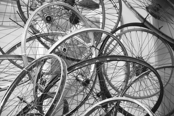 Fototapeta na wymiar Many old used rusty bicycle wheels rims, black and white photo