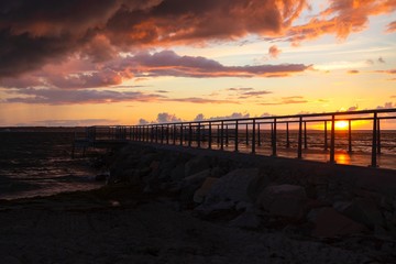 Obraz premium Dramatic summer sunset over sea. Scenic landscape with pier on the sea during beautiful sunset. Sweden