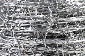 Close up A bundle of Galvanized Barbed Wire or Barb Wire Fencing with sharp edges isolated on white background.