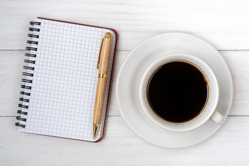 Obraz na płótnie Canvas Coffee cup and blank notebook