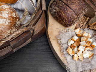 Several types of fresh bread and crackers lying on an wooden table, copy space