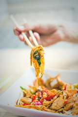 man hand with chopsticks eat thai food closeup selective focus