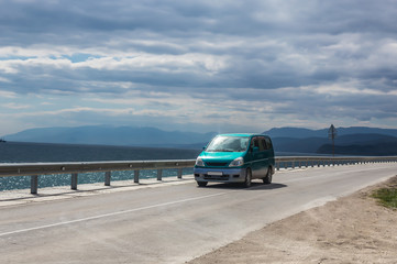 Fototapeta na wymiar Minivan moves on the highway along the sea