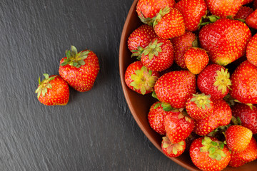 Top of view fresh strawberry in wrought plate on concrete board.
