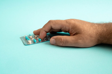 pills in hand isolated on blue