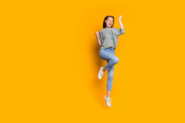 Fototapeta na wymiar Full length body size photo of cheerful overjoyed lady having evidently just been promoted at work while isolated with yellow vivid background