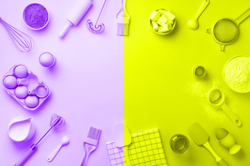 Bakery ingredients over trendy neon yellow and violet color background - butter, sugar, flour, eggs, oil, spoon, rolling pin. Baking frame, cooking concept. Top view, copy space. Flat lay