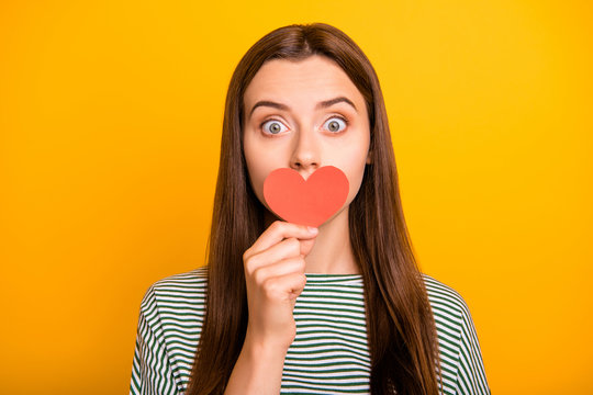 Close up photo of ashamed girl seeming to have told someone her secret while isolated with yellow background