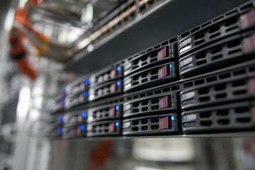 Computer Server mount on rack in data center room with red lighting alarm.