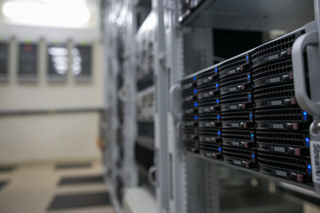 Computer Server mount on rack in data center room with red lighting alarm.