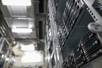 Computer Server mount on rack in data center room with red lighting alarm.